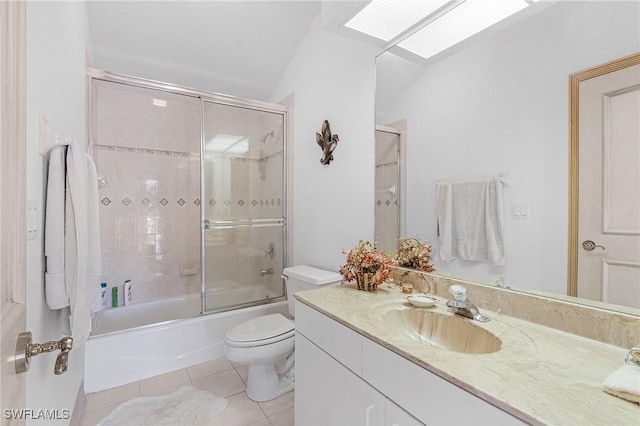 bathroom with vaulted ceiling with skylight, toilet, bath / shower combo with glass door, vanity, and tile patterned floors