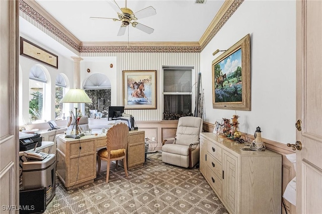 home office featuring a wainscoted wall, crown molding, decorative columns, a decorative wall, and ceiling fan