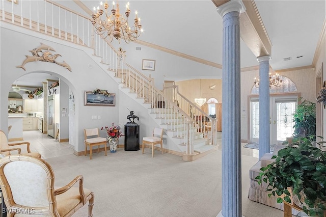 living area with ornamental molding, light carpet, a chandelier, ornate columns, and stairs