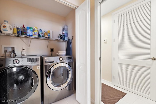 clothes washing area featuring washing machine and dryer and light tile patterned floors