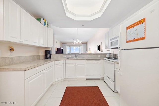 kitchen with white appliances, decorative light fixtures, kitchen peninsula, and white cabinets