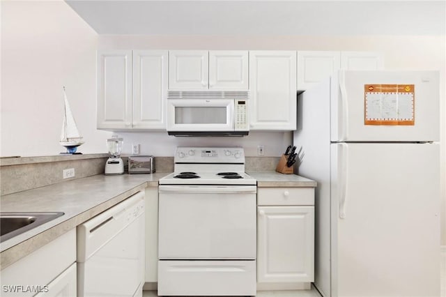 kitchen with white appliances, sink, and white cabinets