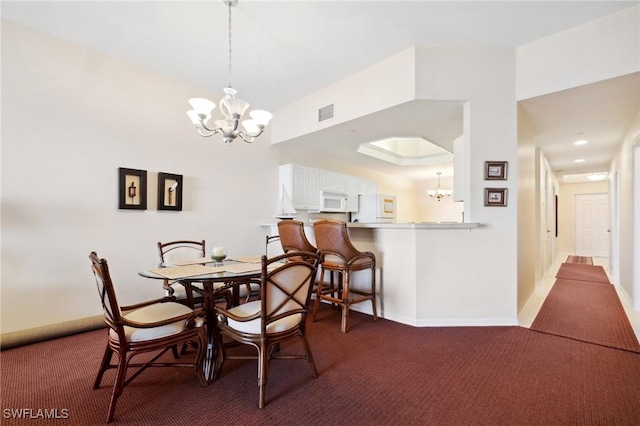 carpeted dining area with a notable chandelier