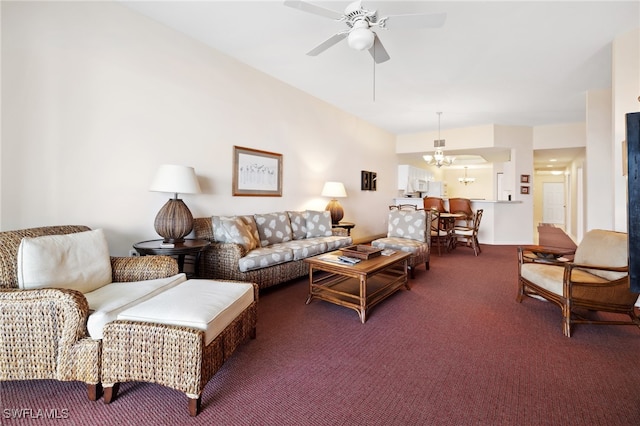 carpeted living room with ceiling fan with notable chandelier