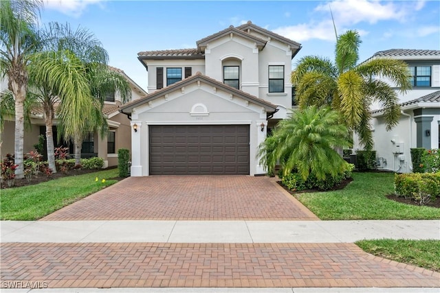 mediterranean / spanish home featuring a garage and a front yard