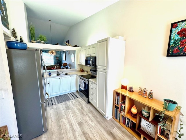 kitchen featuring sink, vaulted ceiling, light hardwood / wood-style floors, and appliances with stainless steel finishes