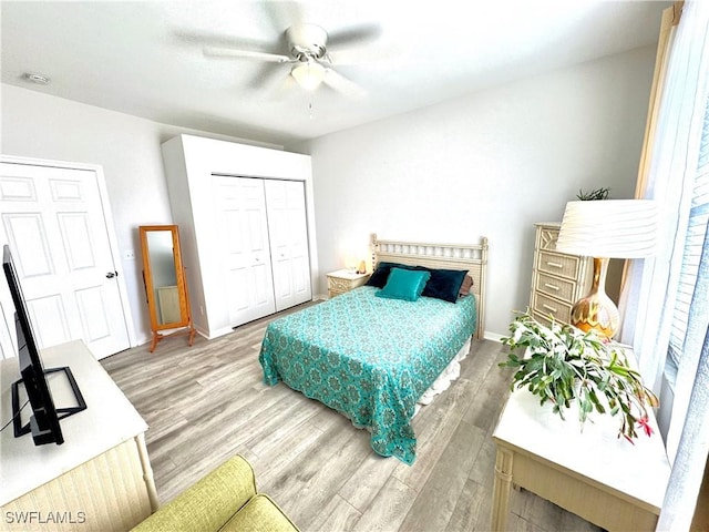 bedroom featuring wood-type flooring, ceiling fan, and a closet