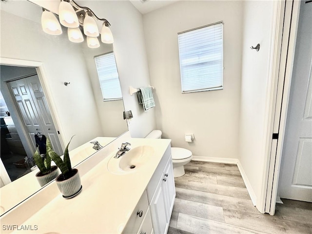 bathroom with vanity, toilet, and hardwood / wood-style floors