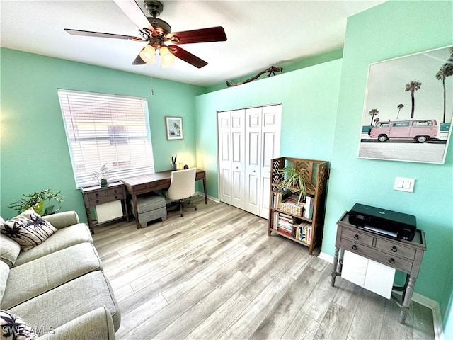 home office with ceiling fan and light hardwood / wood-style flooring