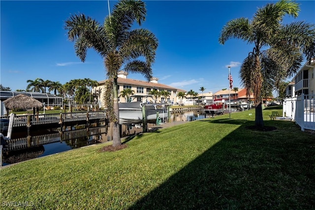 dock area with a lawn and a water view