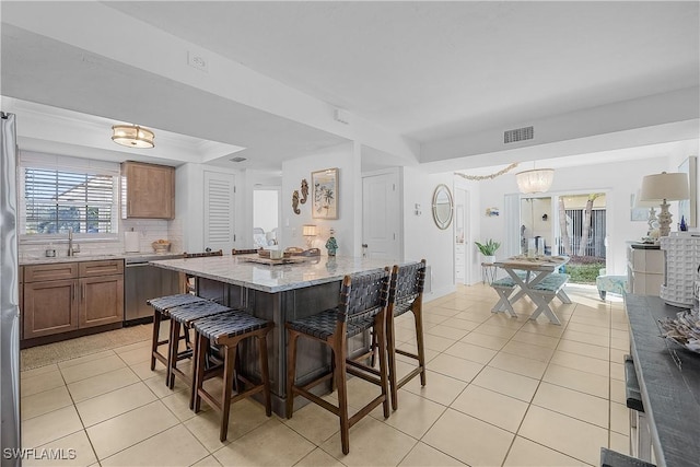 tiled dining space featuring an inviting chandelier and sink