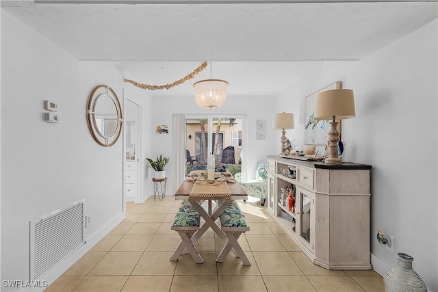 dining room featuring light tile patterned flooring and a chandelier