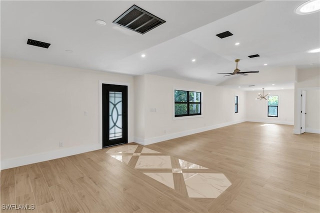 spare room featuring recessed lighting, visible vents, light wood-style floors, baseboards, and ceiling fan with notable chandelier