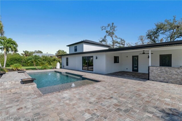 pool with a ceiling fan and a patio area