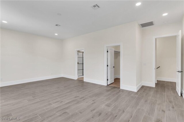 spare room featuring baseboards, light wood finished floors, visible vents, and recessed lighting