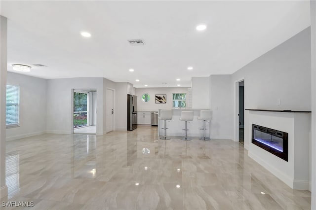 unfurnished living room featuring plenty of natural light