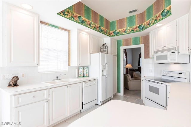 kitchen with a sink, light tile patterned flooring, white appliances, light countertops, and visible vents