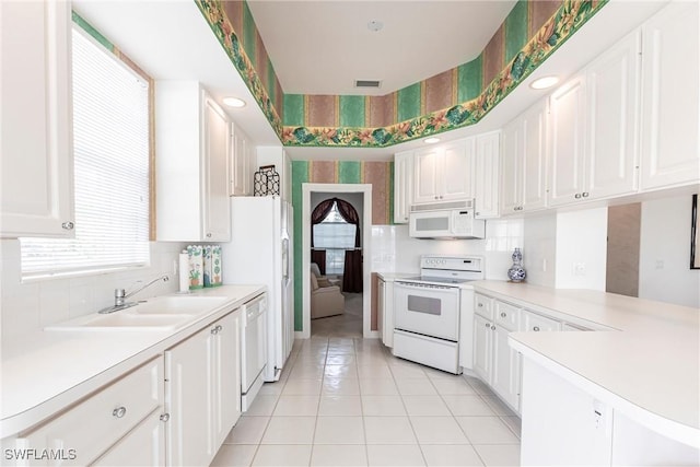 kitchen with white cabinetry, a sink, white appliances, and light countertops