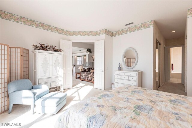 bedroom featuring visible vents and light colored carpet