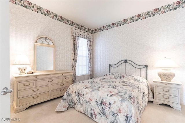 bedroom featuring light colored carpet and wallpapered walls