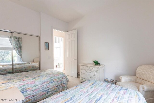 bedroom featuring light colored carpet and a closet