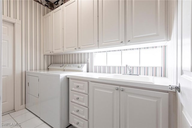 laundry room with washer and clothes dryer, wallpapered walls, a sink, light tile patterned floors, and cabinet space