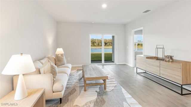 living area with light wood finished floors, baseboards, visible vents, and recessed lighting