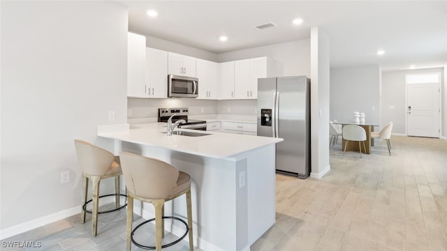 16768 Elkhorn Coral Dr, North Fort Myers, FL 33903 - kitchen featuring appliances with stainless steel finishes, a sink, a breakfast bar, light countertops, and a peninsula