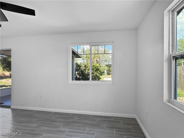 empty room with baseboards, a ceiling fan, and wood finish floors