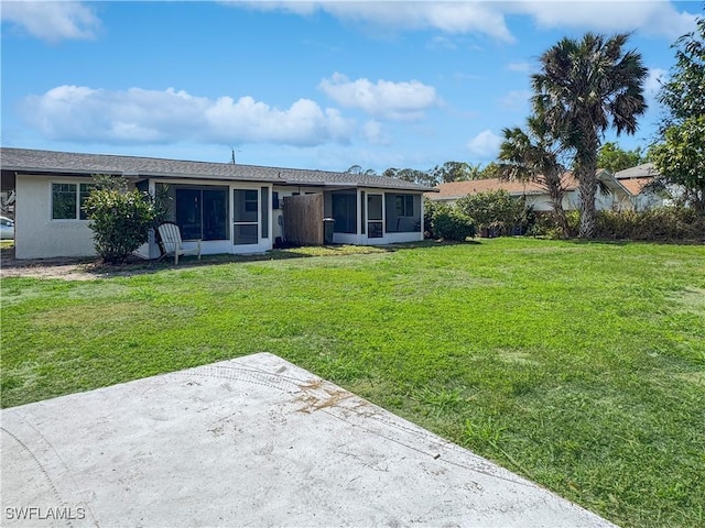 view of front of property featuring a sunroom and a front lawn