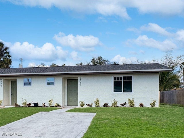 ranch-style house featuring roof with shingles, fence, a front lawn, and stucco siding