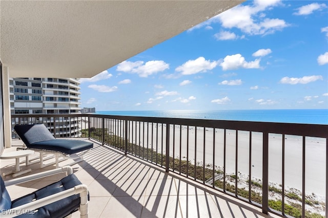 balcony featuring a water view and a view of the beach