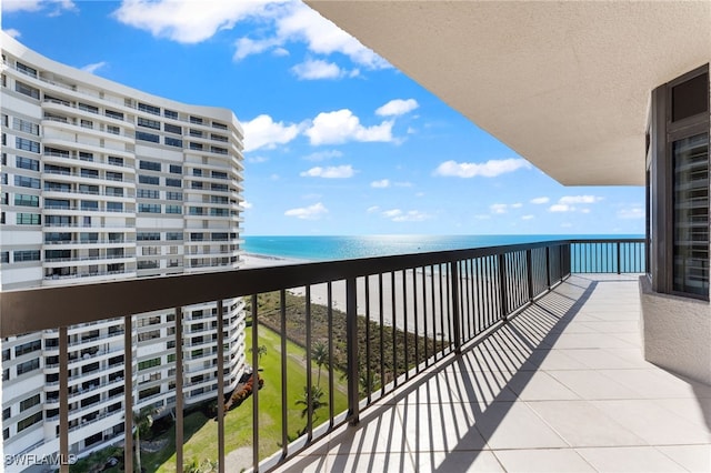 balcony featuring a view of the beach and a water view