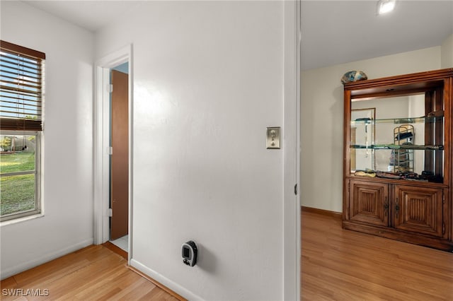 corridor with light hardwood / wood-style floors