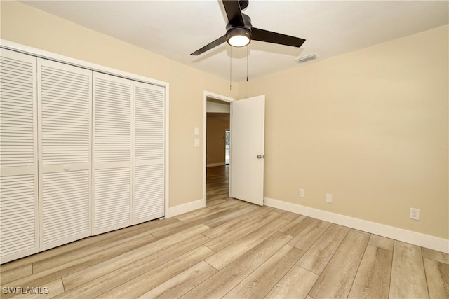 unfurnished bedroom featuring ceiling fan, a closet, and light hardwood / wood-style flooring