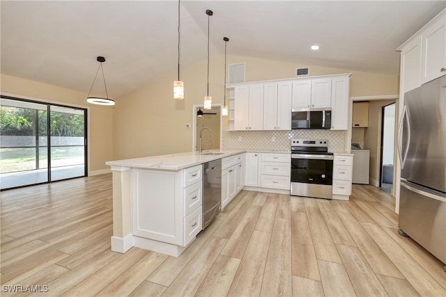 kitchen with lofted ceiling, white cabinetry, decorative light fixtures, stainless steel appliances, and backsplash