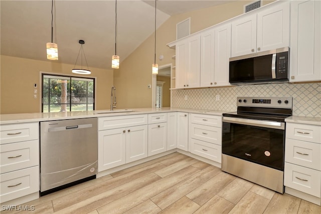 kitchen with pendant lighting, sink, stainless steel appliances, and white cabinets