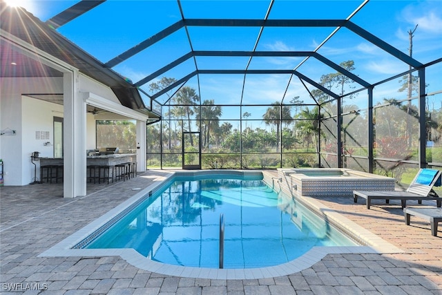 view of swimming pool featuring an in ground hot tub, exterior bar, glass enclosure, and a patio area