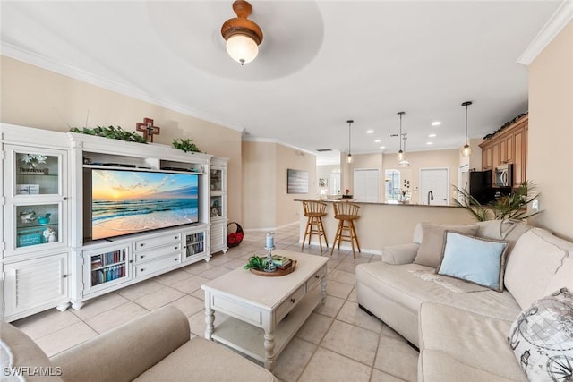 living room featuring light tile patterned floors, ornamental molding, baseboards, and recessed lighting