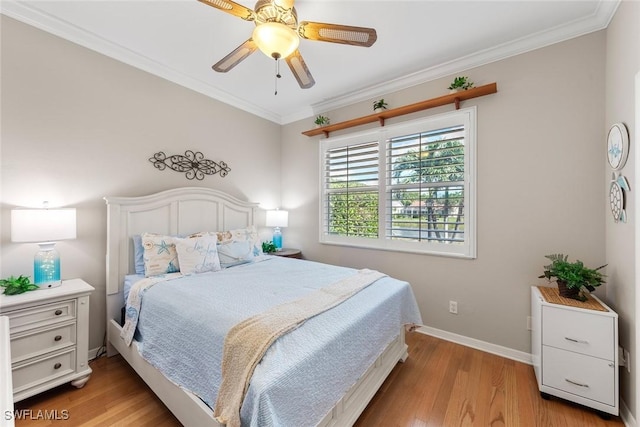 bedroom featuring ornamental molding, light wood-type flooring, a ceiling fan, and baseboards