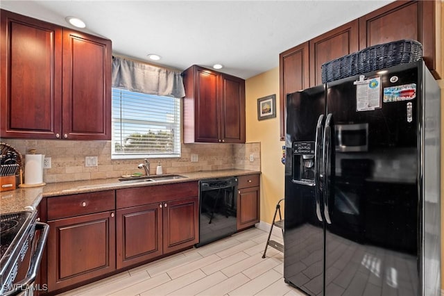 kitchen featuring sink, backsplash, black appliances, and light stone countertops