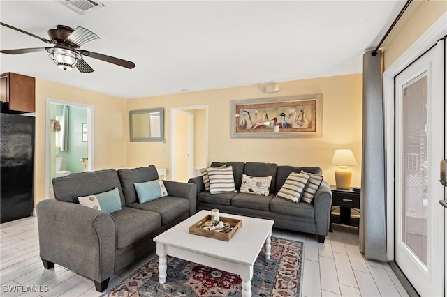 living room with light wood-type flooring and ceiling fan