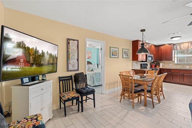 dining space featuring sink, ceiling fan, and light hardwood / wood-style floors