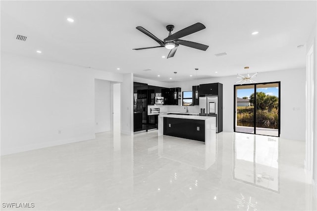 kitchen with recessed lighting, light countertops, visible vents, a kitchen island, and dark cabinets