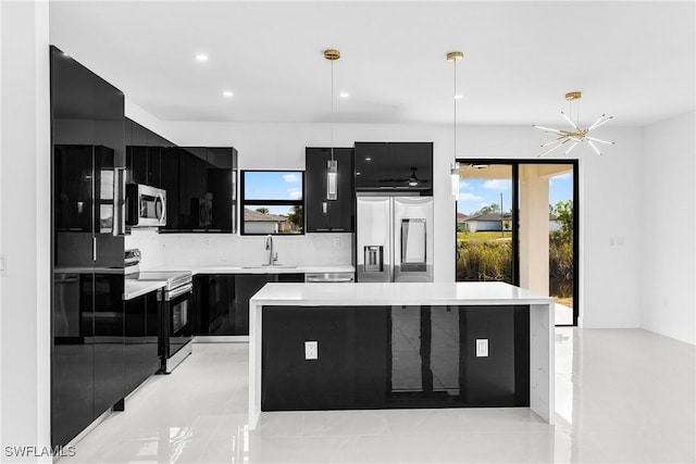 kitchen with stainless steel appliances, light countertops, a center island, and decorative light fixtures