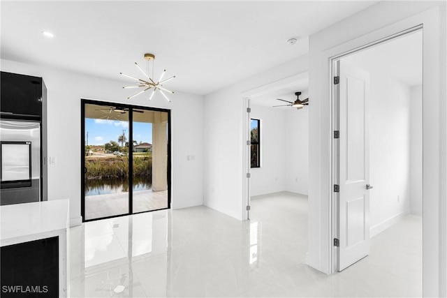 spare room featuring ceiling fan with notable chandelier