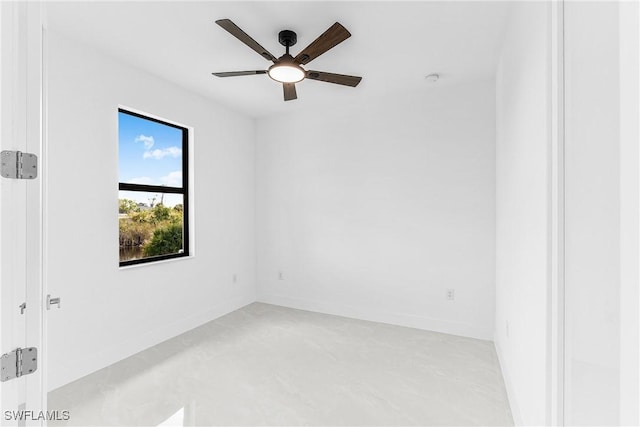 spare room featuring baseboards, a ceiling fan, and finished concrete floors