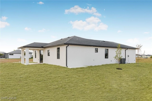 back of house featuring a patio area, central AC unit, stucco siding, and a yard