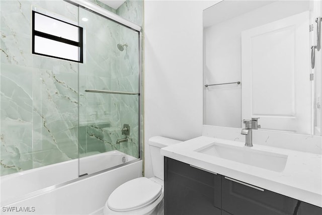 bathroom featuring bath / shower combo with glass door, vanity, and toilet