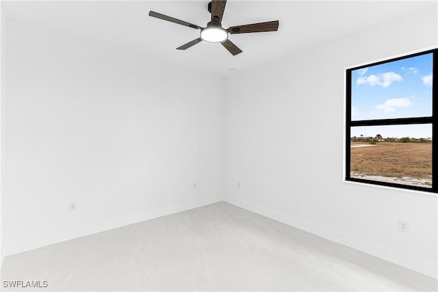 empty room featuring a ceiling fan and baseboards